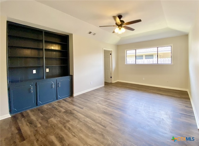 507 Santa Fe, Victoria, TX 77904 - unfurnished room featuring a ceiling fan, dark wood-type flooring, a raised ceiling, and built in shelves