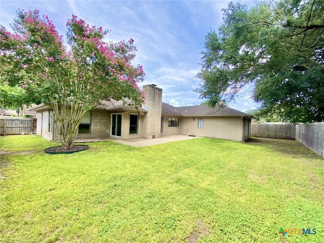 507 Santa Fe, Victoria, TX 77904 - back of property with a chimney, a fenced backyard, and a patio