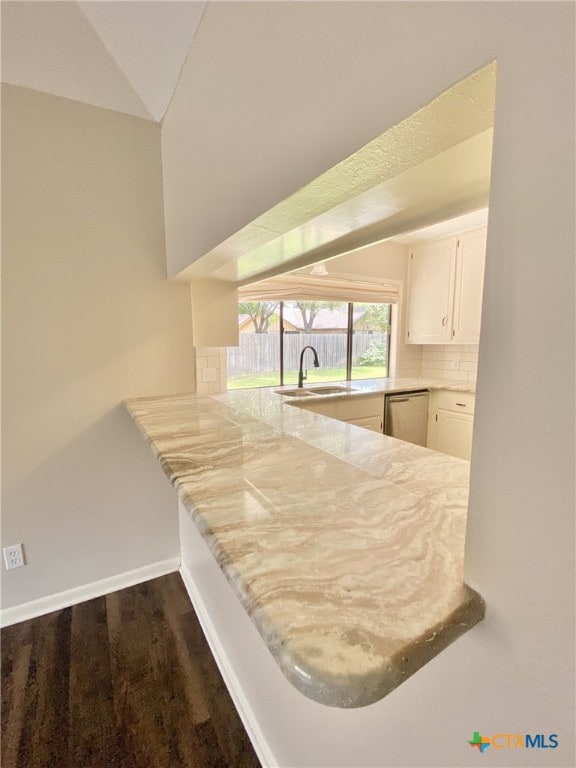 507 Santa Fe, Victoria, TX 77904 - kitchen with stainless steel dishwasher, a peninsula, tasteful backsplash, white cabinets, and dark wood finished floors