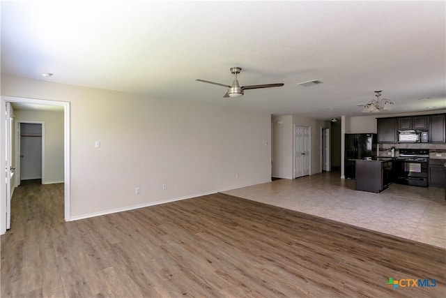 1321 Cozy Creek Dr, Temple, TX 76502 - unfurnished living room featuring light wood finished floors, a chandelier, and ceiling fan