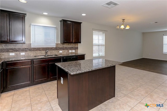 1321 Cozy Creek Dr, Temple, TX 76502 - kitchen featuring dark stone counters, a chandelier, tasteful backsplash, dark brown cabinets, and light tile patterned floors