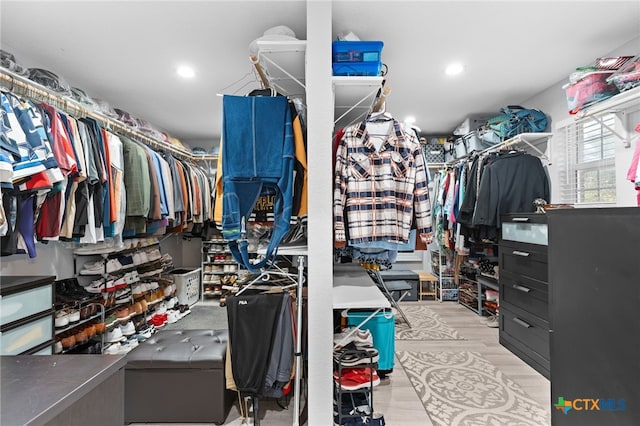 walk in closet with wood finished floors