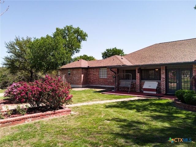 view of yard with french doors and a wooden deck