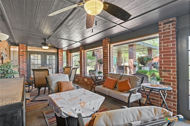 sunroom / solarium with brick wall, french doors, wooden ceiling, and a healthy amount of sunlight