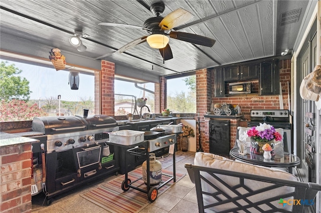 view of patio / terrace featuring area for grilling, ceiling fan, visible vents, a sink, and exterior kitchen