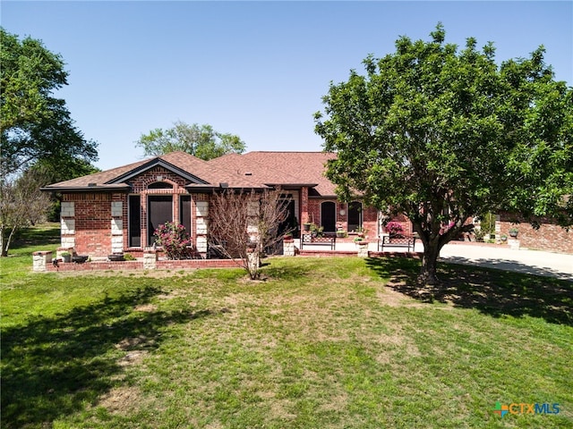 ranch-style house featuring a front lawn and brick siding