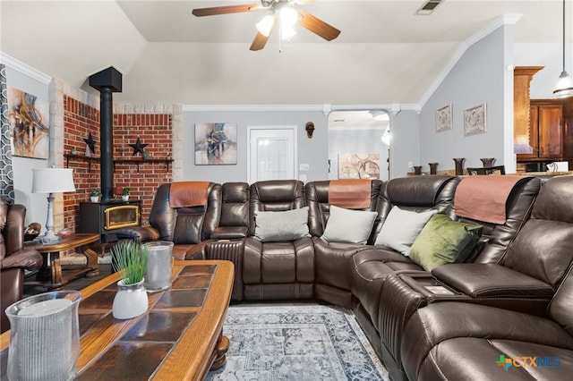 cinema room featuring ornamental molding, a wood stove, a ceiling fan, and lofted ceiling