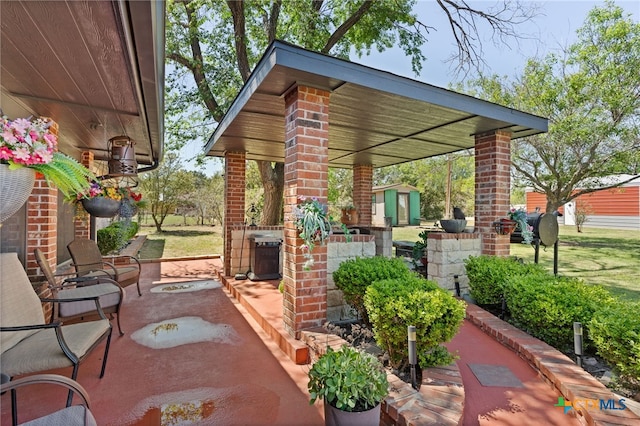 view of patio / terrace with an outdoor structure and a shed