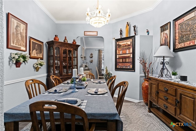 dining space featuring arched walkways, an inviting chandelier, baseboards, and ornamental molding