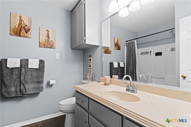 bathroom featuring baseboards, a shower with curtain, toilet, vanity, and wood finished floors