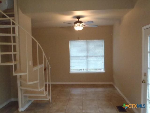 interior space with ceiling fan and tile patterned flooring