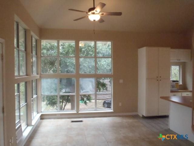 interior space featuring ceiling fan and plenty of natural light