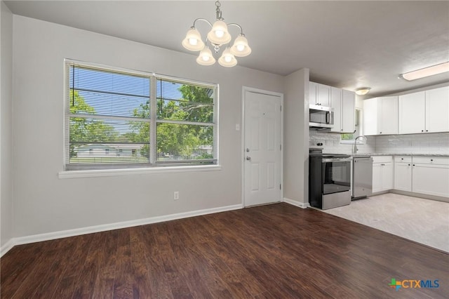 716 S 3rd St, Copperas Cove, TX 76522 - kitchen with appliances with stainless steel finishes, a chandelier, wood finished floors, and white cabinetry
