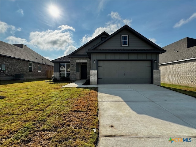 view of front of house with a garage, a front lawn, and central AC