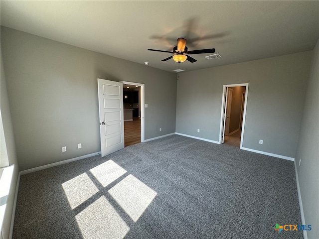 unfurnished bedroom with ceiling fan and dark carpet