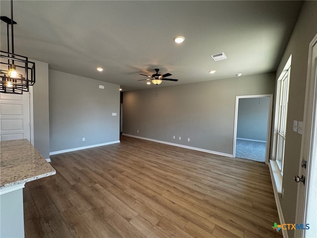 unfurnished living room featuring hardwood / wood-style flooring and ceiling fan