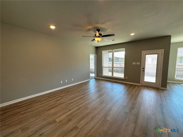 unfurnished room featuring hardwood / wood-style floors, ceiling fan, and a textured ceiling