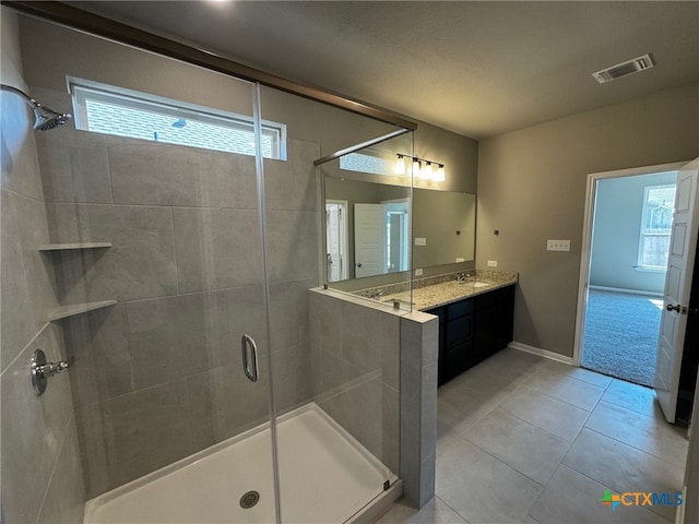 bathroom with an enclosed shower, vanity, and tile patterned floors