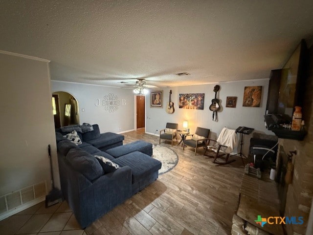 410 Phoenix Dr, Temple, TX 76504 - living room with arched walkways, ceiling fan, wood finished floors, and a textured ceiling