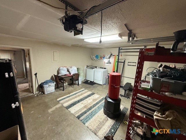 410 Phoenix Dr, Temple, TX 76504 - garage featuring washing machine and clothes dryer, a garage door opener, and freestanding refrigerator