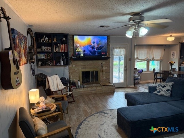 410 Phoenix Dr, Temple, TX 76504 - living room with a textured ceiling, ceiling fan, wood finished floors, and a brick fireplace