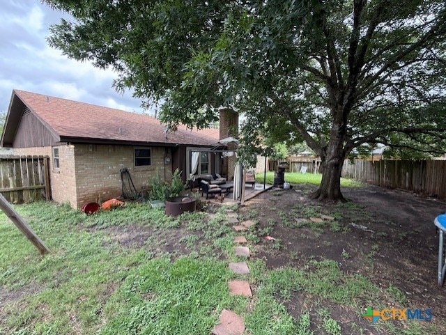 410 Phoenix Dr, Temple, TX 76504 - rear view of house with a fenced backyard, brick siding, a chimney, and a patio