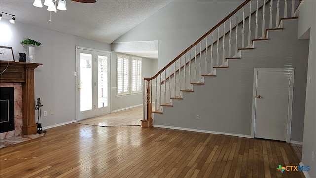 entrance foyer featuring wood-type flooring, a textured ceiling, ceiling fan, and vaulted ceiling