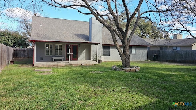 rear view of house with a yard, a fenced backyard, and a patio area