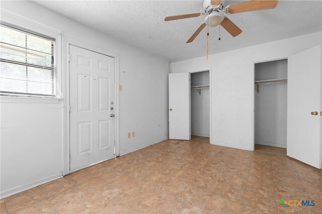 1202 S 3rd St, Copperas Cove, TX 76522 - unfurnished bedroom with multiple closets, a textured ceiling, and a ceiling fan