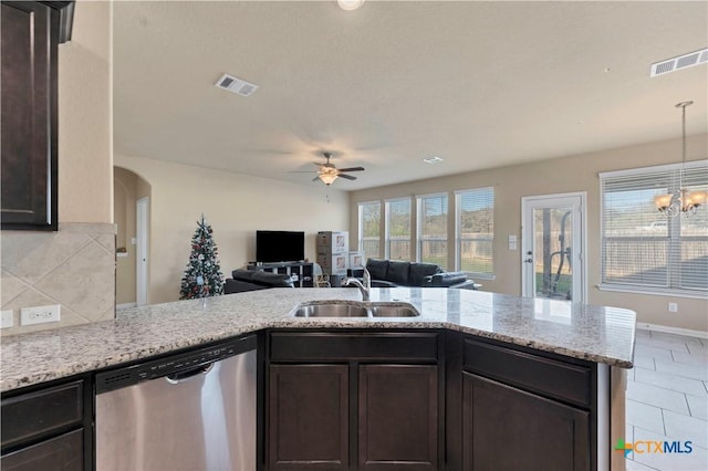 kitchen with sink, stainless steel dishwasher, backsplash, kitchen peninsula, and dark brown cabinets