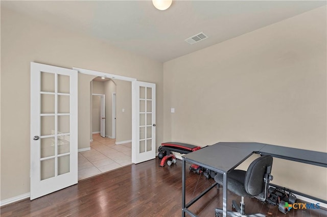 home office with french doors and hardwood / wood-style floors