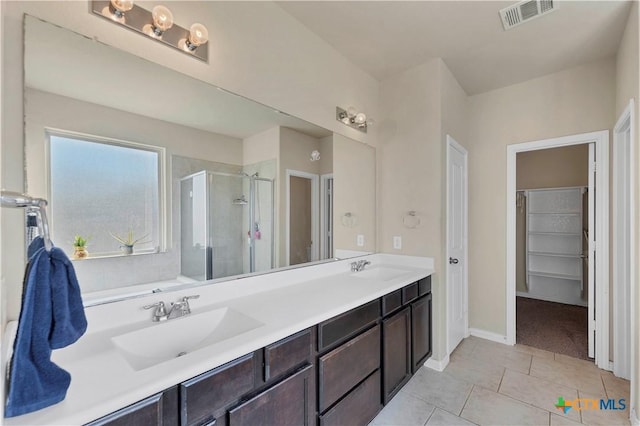 bathroom featuring tile patterned flooring, vanity, and a shower with shower door