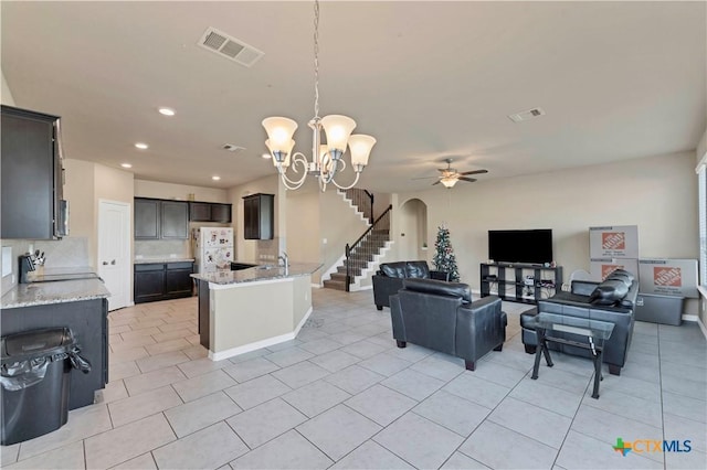 interior space featuring ceiling fan with notable chandelier