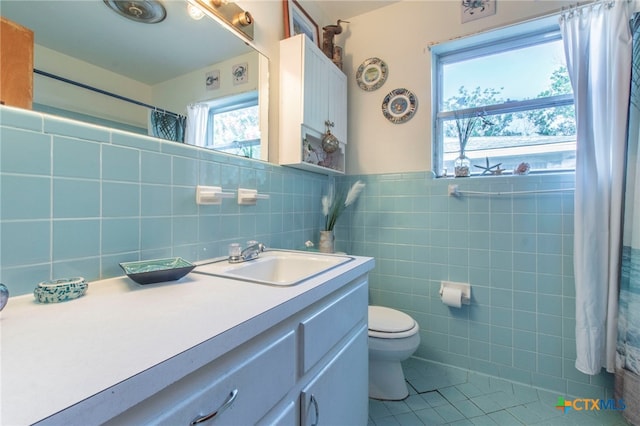 1105 E Robertson Ave, Copperas Cove, TX 76522 - bathroom featuring tile patterned floors, tile walls, vanity, a wainscoted wall, and curtained shower