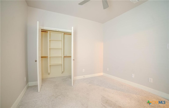 unfurnished bedroom with a closet, carpet floors, baseboards, and ceiling fan