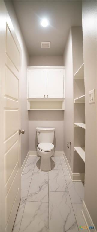 bathroom with toilet, visible vents, marble finish floor, and baseboards