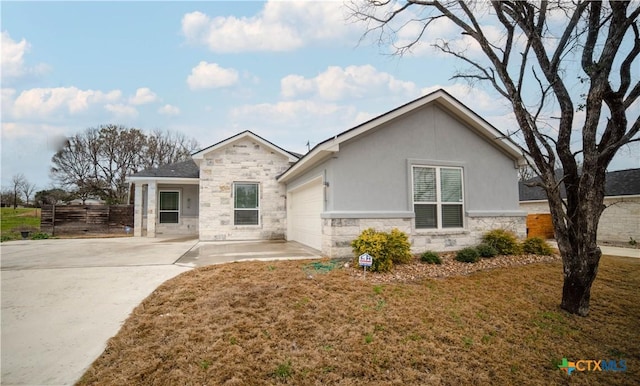 single story home featuring stucco siding, stone siding, fence, a front yard, and a garage