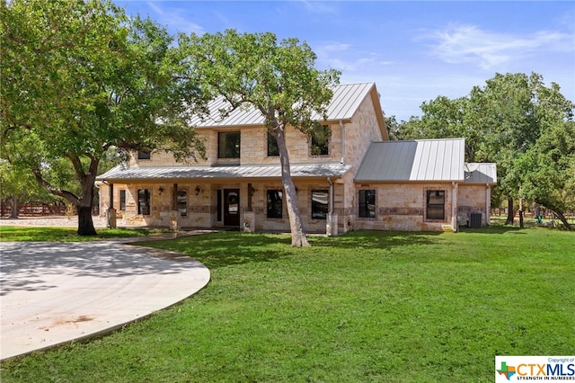 view of front facade featuring central AC unit and a front yard