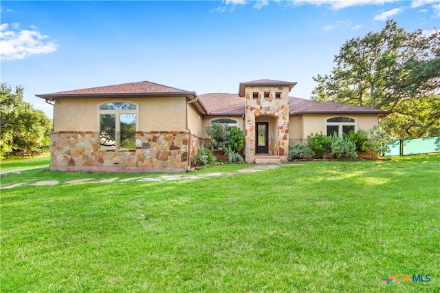 mediterranean / spanish home featuring a front lawn