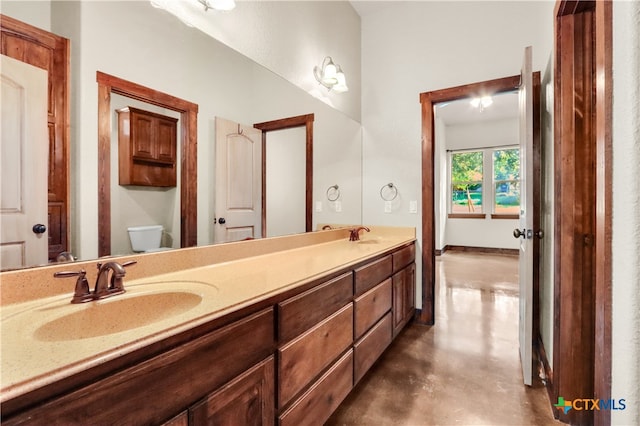 bathroom featuring concrete flooring, vanity, and toilet