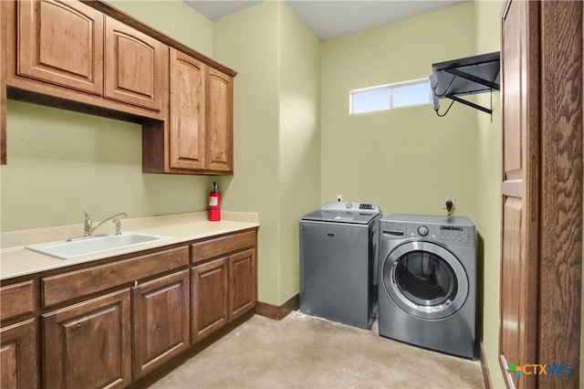 clothes washing area featuring cabinets, separate washer and dryer, light carpet, and sink