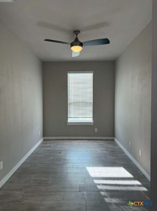 unfurnished room featuring ceiling fan and dark wood-type flooring