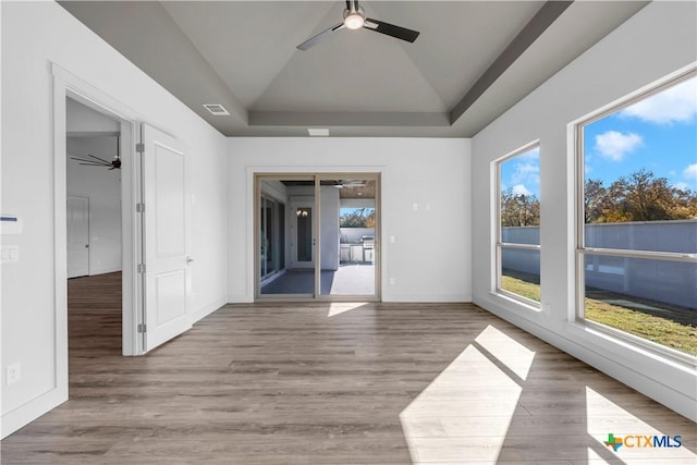 105 Gillespie Ct, Horseshoe Bay, TX 78657 - empty room with ceiling fan, wood finished floors, lofted ceiling, and a tray ceiling