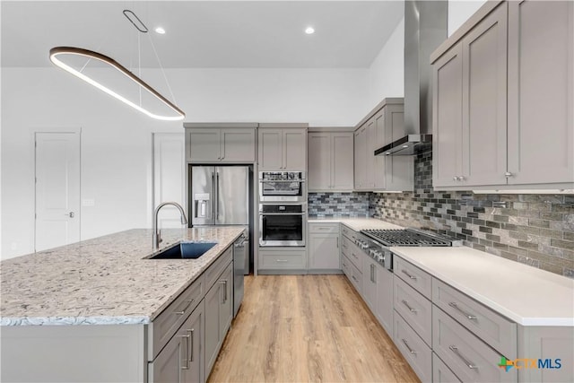 105 Gillespie Ct, Horseshoe Bay, TX 78657 - kitchen featuring gray cabinets, a sink, wall chimney range hood, stainless steel appliances, and light wood-style floors