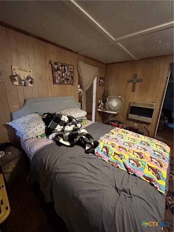 bedroom featuring wooden walls and heating unit