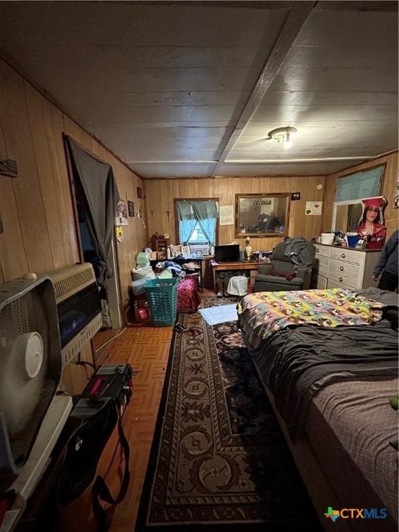 bedroom with heating unit and wooden walls