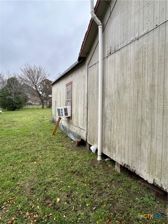 view of side of home with a yard and cooling unit