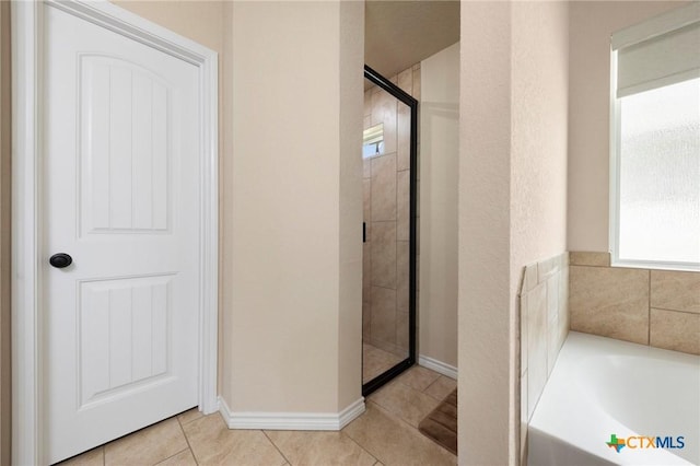 6105 Dorado Dr, Killeen, TX 76542 - bathroom featuring a bath, tile patterned flooring, a shower stall, and baseboards