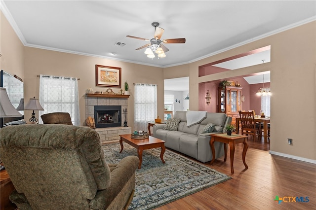 1712 Indian Camp Trl, Copperas Cove, TX 76522 - living area featuring a chandelier, a ceiling fan, wood finished floors, crown molding, and a fireplace with raised hearth