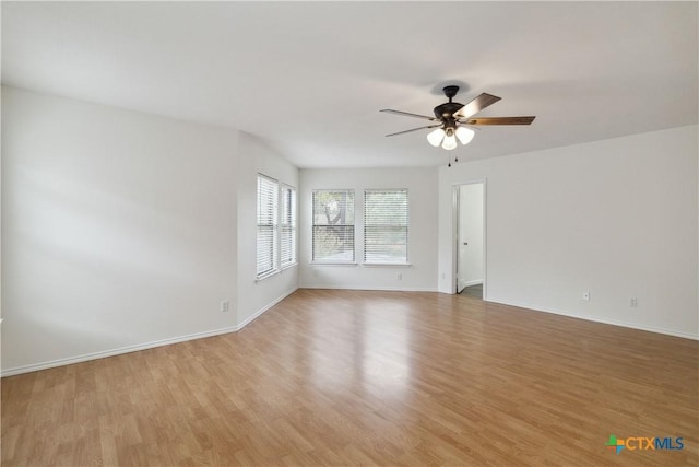 empty room with ceiling fan and light hardwood / wood-style flooring